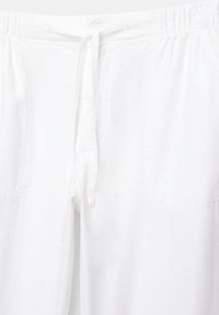 Hvide, lette bukser med elastisk taljebånd og justerbar snor. Har lommer og en blød, åndbar struktur.