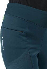 Marineblaue Sportleggings mit hohem Taillenbund, Reißverschlusstasche und strukturierten Einsätzen. Mit Logo-Branding an der Seite.