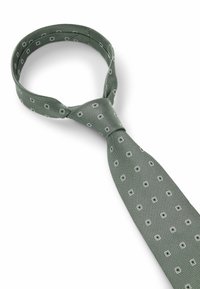 Groene stropdas met een textuurweefsel, voorzien van kleine witte vierkante patronen. Het ontwerp is symmetrisch, met een standaard stropdasvorm en knoop.