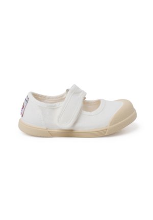 Scarpa Mary Jane in tela bianca con strap in velcro, punta arrotondata e suola in gomma beige. Presenta un patch decorativo colorato sul lato.