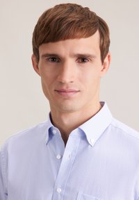 Camicia azzurro chiaro con bottoni, con un delicato motivo geometrico, colletto classico e texture liscia.