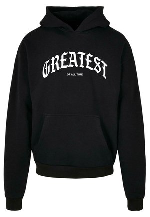 Zwarte hoodie van katoen, met een voorzak, ribgebreide manchetten en onderrand, en witte tekst "GREATEST OF ALL TIME" op de borst.