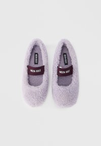 Zapatillas de estar por casa de color lavanda, con textura suave y punta redondeada. Cuentan con una correa elástica burdeos con la marca "MOON BOOT".