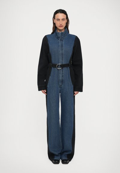 Denim jumpsuit met een aangesloten lijfje, hoge kraag, lange zwarte mouwen, wijde pijpen en een zwarte riem met een ronde gesp. Bivanige uitvoering.