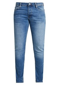Jeans de mezclilla azul ajustados que presentan una cintura de media altura, diseño de cinco bolsillos y un acabado desgastado para un aspecto usado.