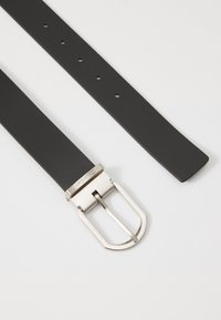 Cintura in pelle nera con una fibbia rettangolare argentata, dotata di cinque fori di regolazione e una finitura liscia e opaca.