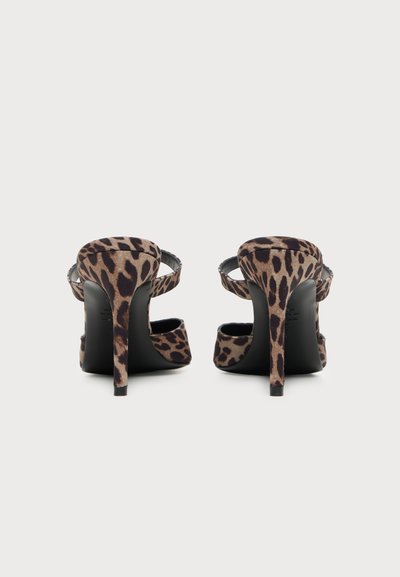 Paire de sandales à talons hauts avec tissu à imprimé léopard et brides à la cheville, vues de dos sur un fond clair uni.