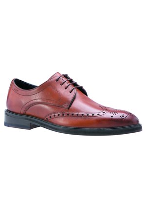 Brun læder oxford selskabssko med brogue-perforeringer, sort sål og sorte snørebånd, vist fra en sidevinkel.