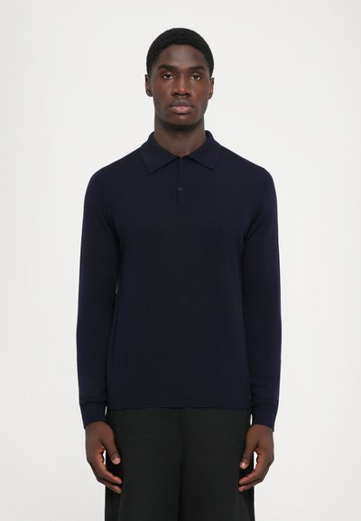 Polo de manga larga en color navy con un patrón de punto texturizado, placket de dos botones y puños acanalados. Diseño limpio y minimalista sin acentos.