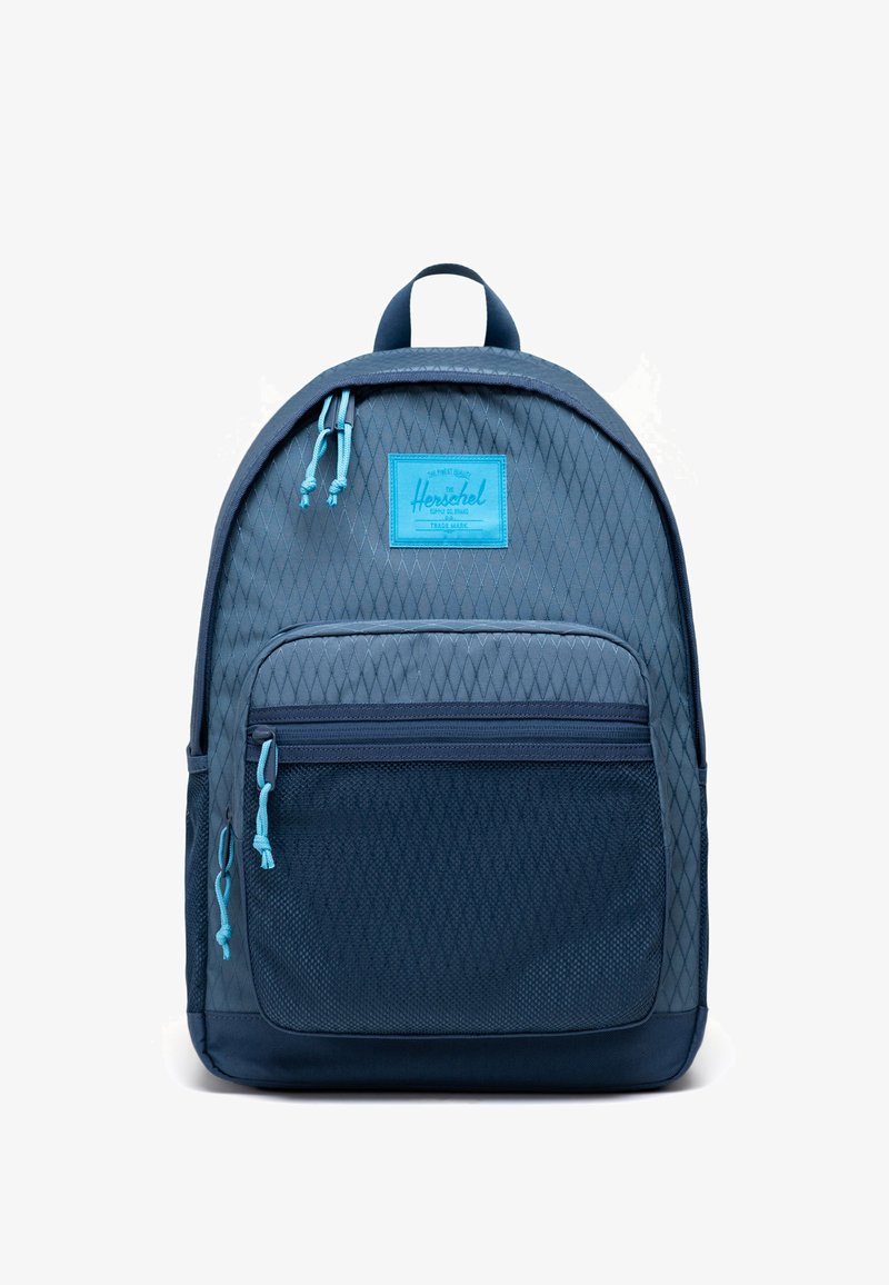 Sac à dos bleu Herschel avec une texture à motif de losanges, poche avant zippée, tirettes turquoise et poignée supérieure, présenté sur fond blanc.