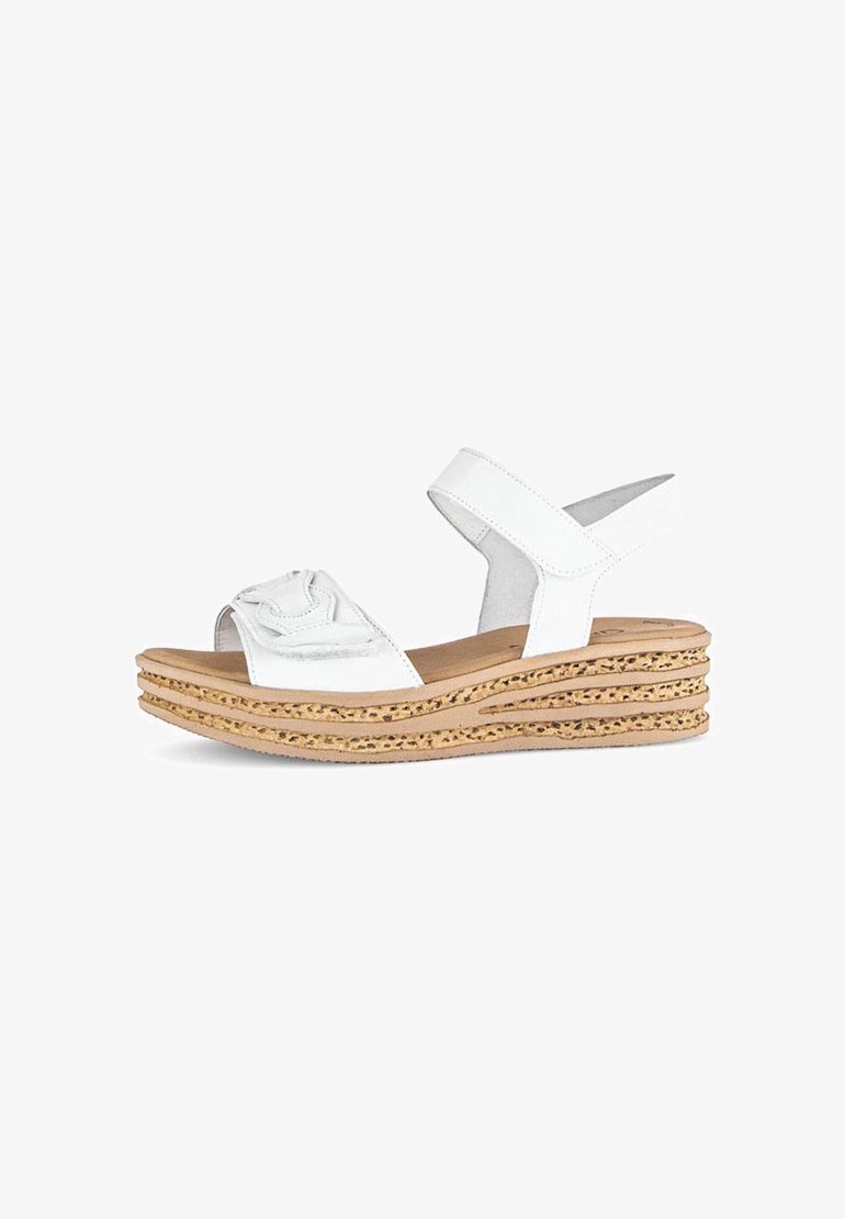 Białe sandały na koturnie z teksturowanym paskiem ozdobionym kokardą, korkową platformą oraz regulowanym paskiem na kostce dla wygody.