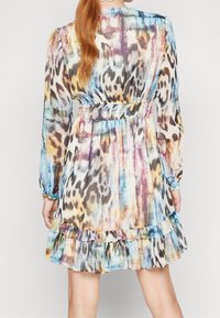 Mehrfarbiges Leopardenmuster-Kleid mit Rüschensaum, langen Ärmeln und elastischem Bund. Hergestellt aus leichtem, strukturiertem Stoff.