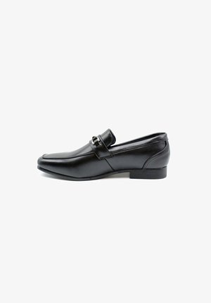 Mocassins en cuir noir avec une finition lisse, bout pointu, sangle décorative et boucle, petit talon empilé et design minimaliste.