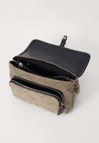 Borsa intrecciata con texture in tonalità terrose, dotata di chiusura con zip, interno nero in contrasto e due tasche frontali con accessori in argento.