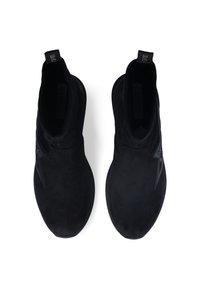 Stivaletti neri in suede con texture liscia, punta rotonda, lati elasticizzati e un'etichetta sul retro per facilitarne l'indossamento.