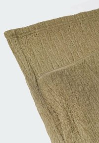 Tissu vert olive texturé avec une apparence froissée, arborant une fermeture éclair sur un bord pour plus de commodité et de style.