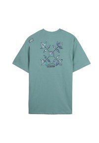 T-shirt en coton vert menthe avec un motif floral aux nuances de bleu et de violet, affichant "Oxbow" au centre. Manches courtes, coupe décontractée.