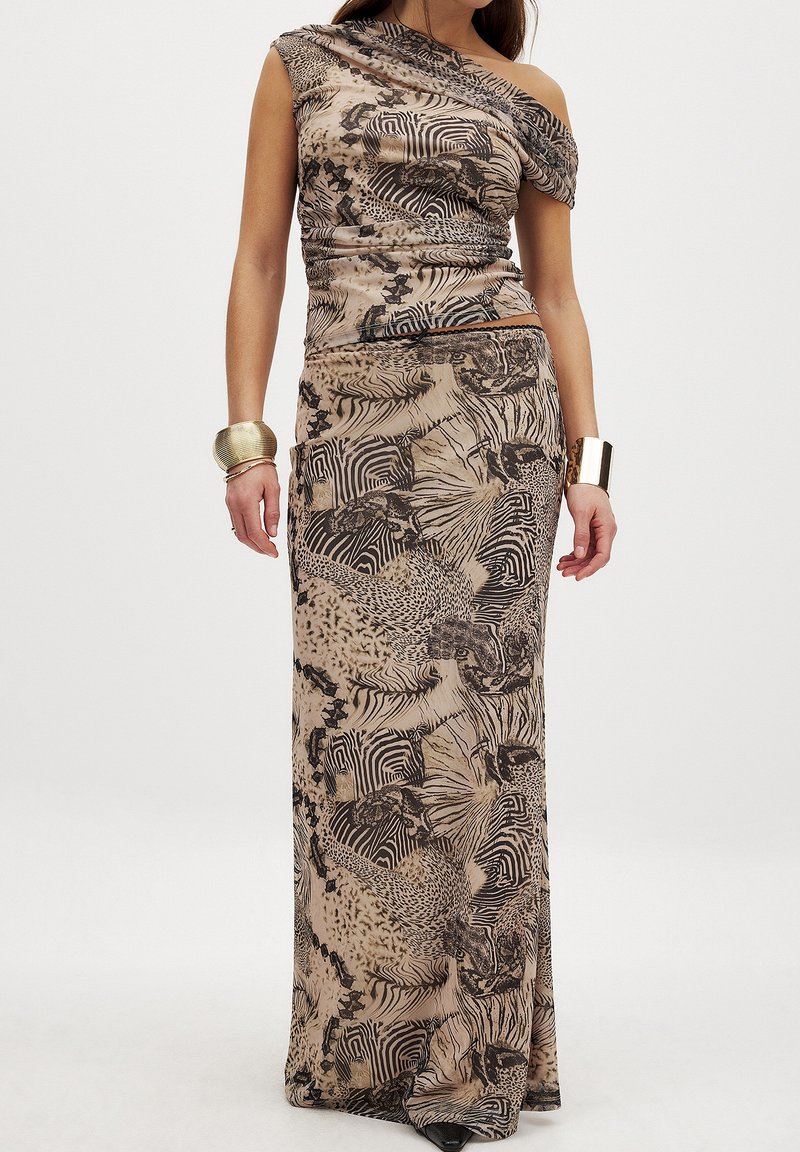 Abito maxi in stampa animale beige e nera con scollatura asimmetrica, corpetto aderente e gonna fluida. Tessuto liscio e dettagli testurizzati.