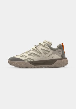 Ljust färgad sneaker med överdel av mesh och mocka, grå gummi tånapp, texturerad sula och orange accent på hälen.