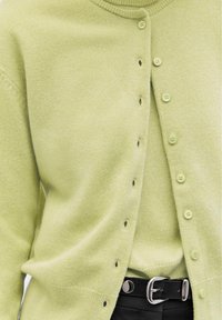 Cardigan verde chiaro realizzato in un tessuto morbido, con scollo rotondo, chiusura a bottoni frontale e bottoni coordinati lungo la pattina.
