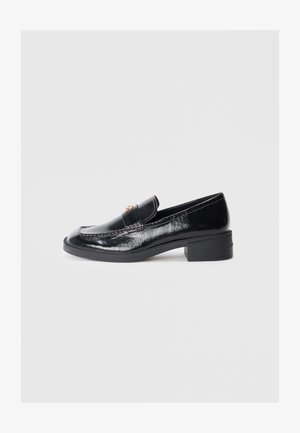 Black patent leather loafers with a low block heel, featuring a stitched design and gold-toned decorative accents on the upper.