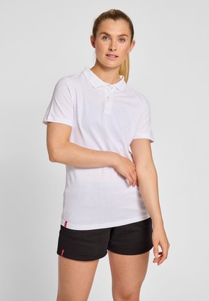 Hvid kortærmet polo-shirt med spids krave, tre knapper og slim fit. Kombineret med sorte shorts med et diskret logo.