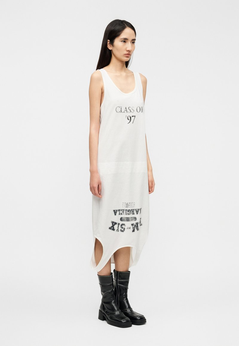 Robe blanche sans manches avec une impression graphique "CLASS OF '97" à l'avant et "VARIETA" à l'arrière ; tissu texturé avec fentes latérales.