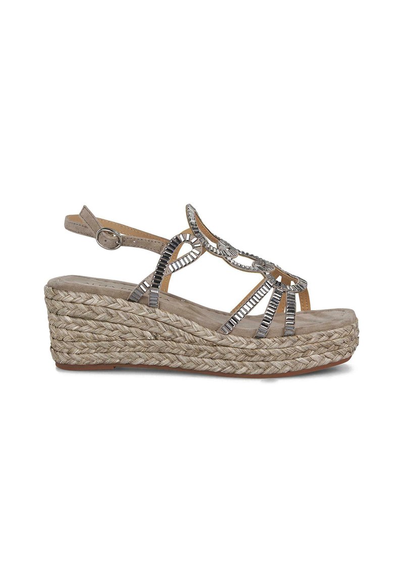 Sandalia de cuña con suela de yute trenzado, parte superior beige, acentos decorativos en plata, diseño de punta abierta y correa en el tobillo ajustable.