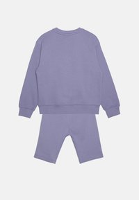 Lila sweatshirt och shorts-set gjort av mjuk bomull, med en avslappnad passform, ribbade ärmslut och en enkel, sömlös design.