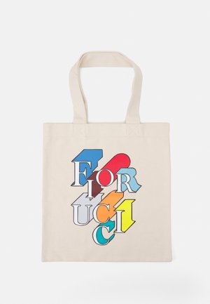Beżowa torba typu tote z grubymi uchwytami, z przodu słowo "Fiorucci" dużymi kolorowymi nakładającymi się literami. Brak osób.