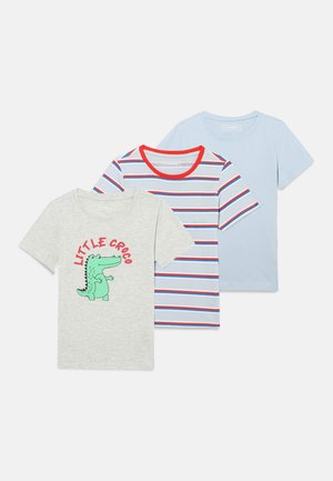 Trois T-shirts à manches courtes pour enfants : un gris avec un crocodile de dessin animé, un rayé bleu-blanc-rouge et un uni bleu clair.
