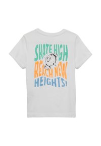 Witte katoenen t-shirt met een grafisch ontwerp waarin de tekst "SKATE HIGH REACH NEW HEIGHTS!" staat in groen, oranje en blauw, boven een cartoonfiguur.