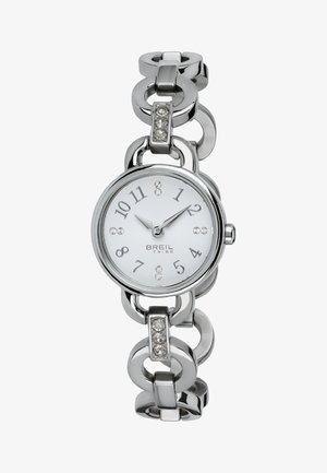 Montre en métal argenté avec un cadran rond, un fond blanc et des chiffres arabes. Présente un design de chaîne articulée et trois accents scintillants sur le bracelet.