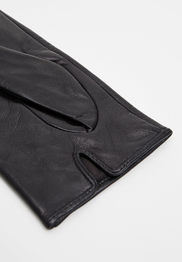 Schwarzer Lederhandschuh mit einem eleganten Design, im fingerlosen Stil, mit strukturiertem Oberflächenmaterial und einem Ausschnitt im Handflächenbereich.