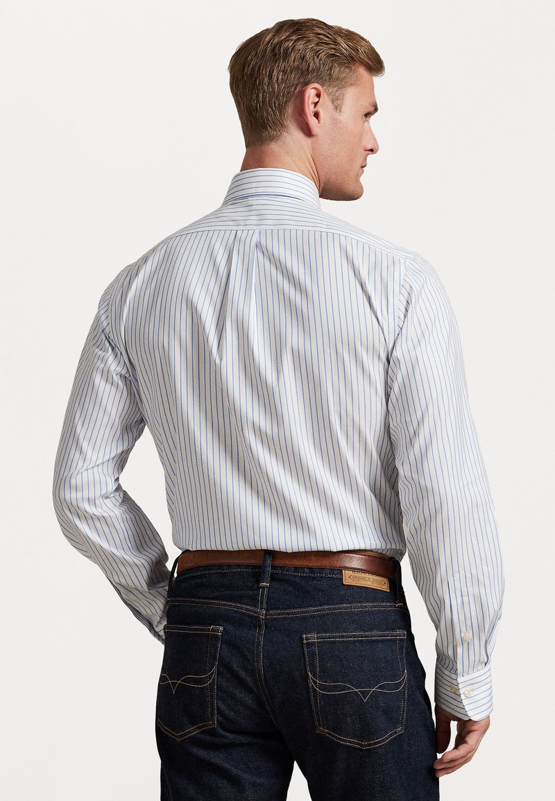 Light blue and white striped button-up shirt, long sleeves, with a spread collar. Paired with dark denim jeans and brown belt.