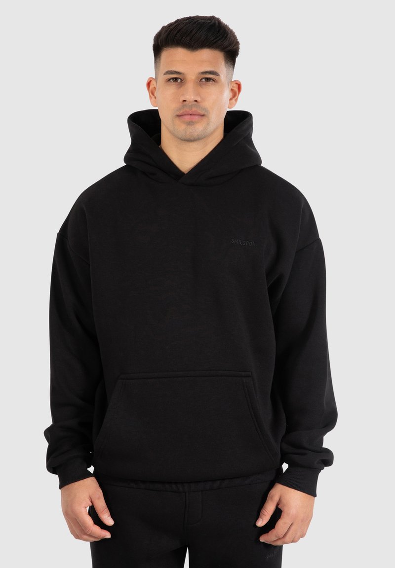 Sweat à capuche noir avec une poche frontale, des poignets et un ourlet côtelés. Présente un logo discret sur la poitrine. Fabriqué en tissu doux et texturé.