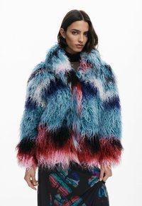 Faux-Fur-Jacke mit einem Farbverlauf in Blau, Pink, Rot und Schwarz, mit langem, welligem Textur und einem breiten Kragen.