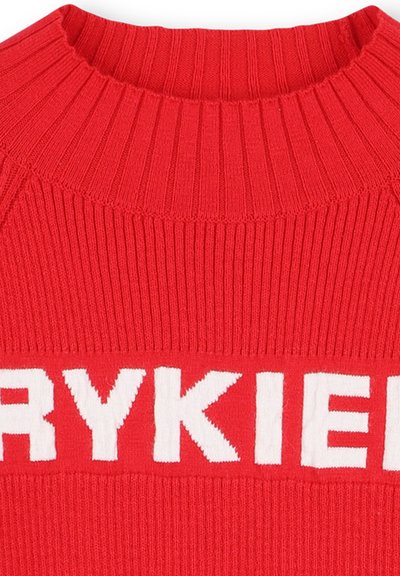 Maglione rosso a coste con collo alto e grande scritta bianca che recita "RYKIE." Il tessuto sembra testurizzato e lavorato a maglia.