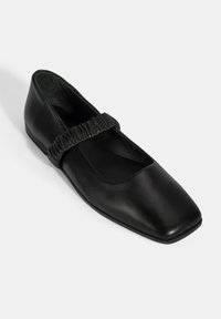 Schwarze Lederflachschuhe mit quadratischer Zehenpartie, ausgestattet mit einem gerafften elastischen Riemen über dem Spann und einem glatten matten Finish.