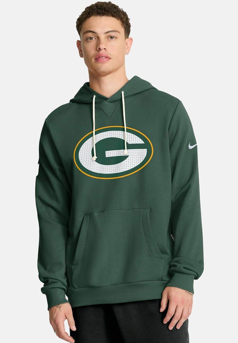 Grüner Kapuzenpullover aus weichem Stoff mit großem rundem Logo, das ein weißes "G" mit gelbem Rand zeigt. Verfügt über eine Fronttasche und Kordelzüge.