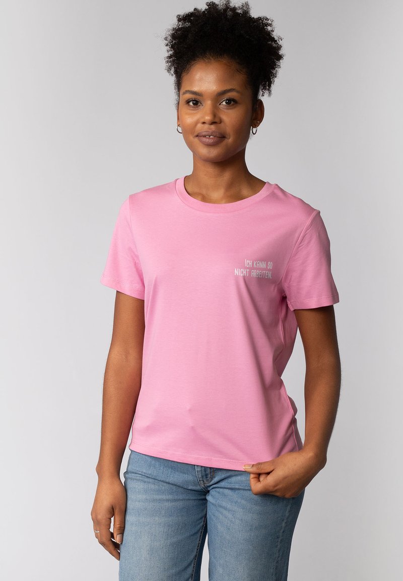 Korte mouwen, ronde hals, roze T-shirt van zachte stof, met lichtgrijze tekst die zegt "Ich kann so nicht arbeiten."