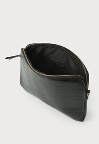 Must beegimust must must mustmust leather bag, millel on krokodille nahk, millel on kuldne tõmblukk, avar interjöör ja sile kangas vooder.