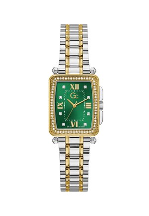 Prostokątny zegarek z zieloną tarczą, złotymi akcentami i pierścieniem wysadzanym diamentami. Bransoleta ze stali nierdzewnej i złota z polerowanym wykończeniem.