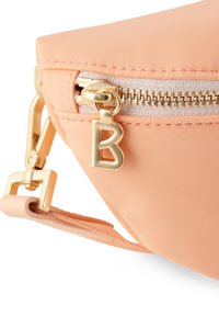Borsa in tessuto color pesca con hardware dorato, dotata di chiusura a zip e di un gancio metallico. Accentuata da un charm a forma di "B" sul tirazip.