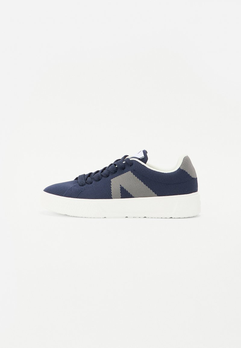 Zapatillas de malla azul marino con suela de goma blanca, punta redonda, parte superior texturizada y detalles en gris en los lados y la parte trasera. Diseño con cordones.