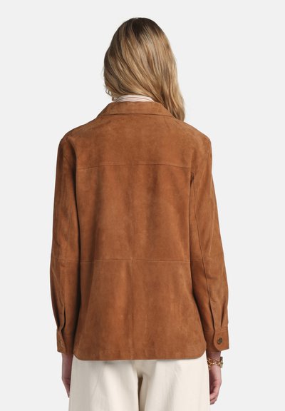 Braune Wildlederjacke mit lockerem Schnitt, ausgestattet mit einem Reverskragen, langen Ärmeln und geknöpften Manschetten, zeigt eine glatte Textur und Nahtdetails.