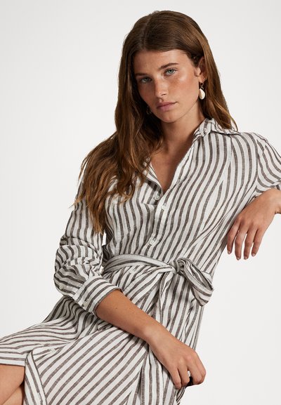 Vestido camisero de lino a rayas en blanco y marrón, con un frente abotonado, mangas largas, cintura ajustada con un lazo y cuello.