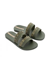 Een paar olijfgroene slip-on sandalen met een gestructureerde voetbed en twee brede banden met gouden golvende patronen over elke band.