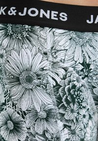 Cintura nera con testo bianco "JACK & JONES." Motivo floreale verde su tessuto morbido, con disegni dettagliati di vari fiori.