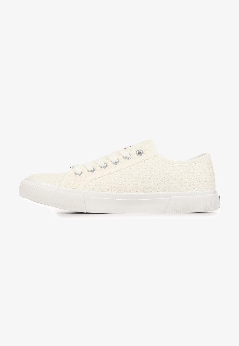 Baskets blanches basses avec dessus en tissu texturé, semelle en caoutchouc blanc, et devant à lacets avec œillets métalliques, vues de côté.